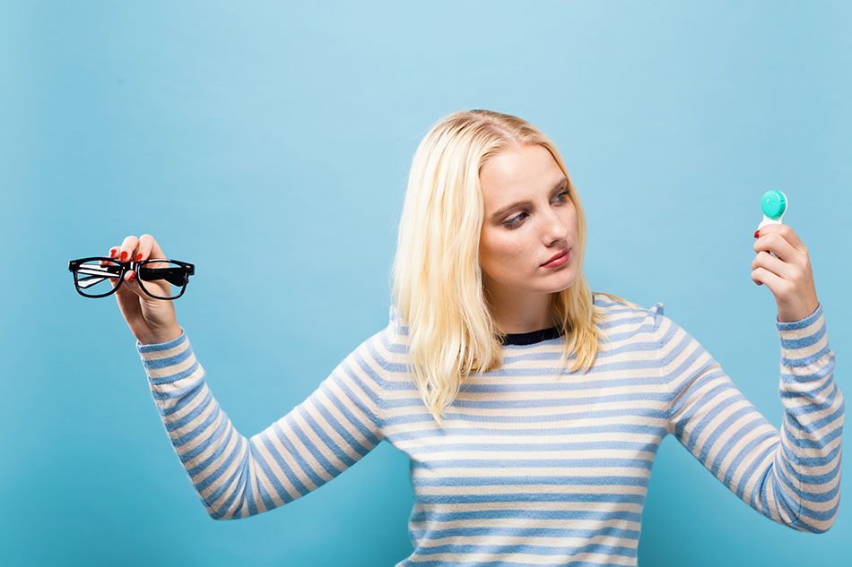 blonde woman deciding between contacts or glasses