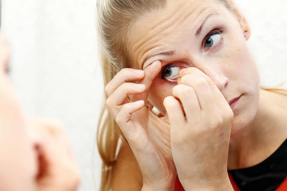 blonde woman removing contact