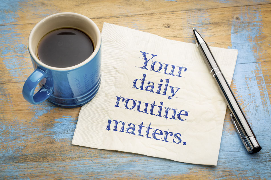 coffee mug, napkin with your daily routine matters written, pen on table