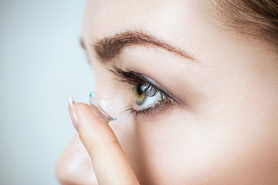 woman inserting daily contact lenses despite allergies