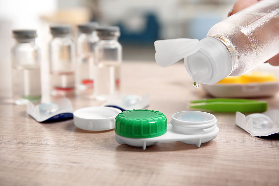 Dripping solution into contact lens case on table