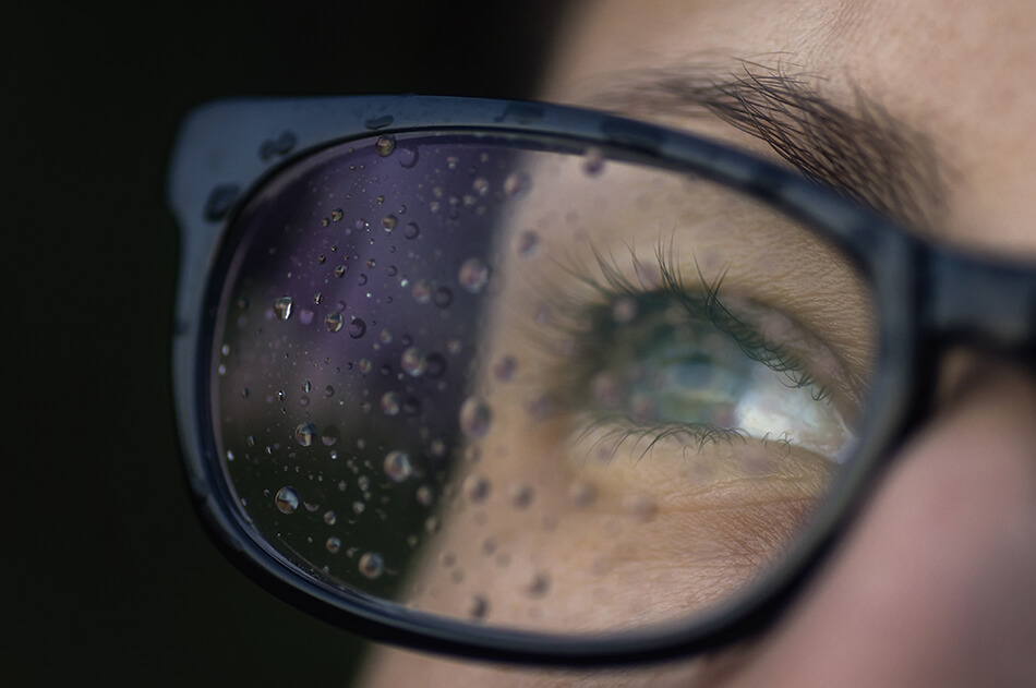 eye behind glasses with raindrops