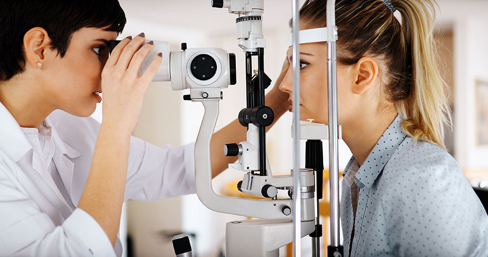 eye doctor giving eye exam to female patient