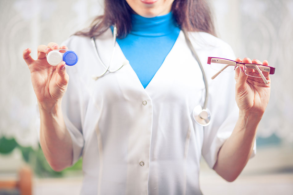 eye doctor holding contact case in one hand, glasses in the other hand