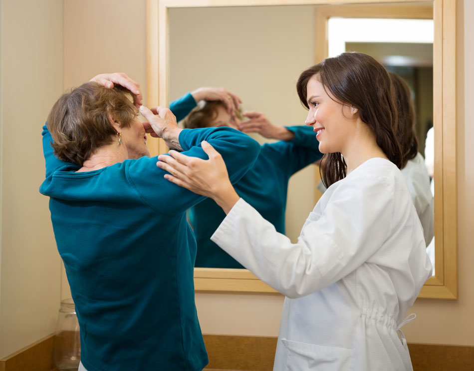 Female eye doctor teaching senior woman how to put in contacts