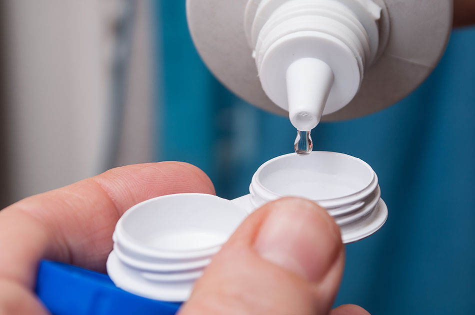close-up of filling a contact lens case with solution