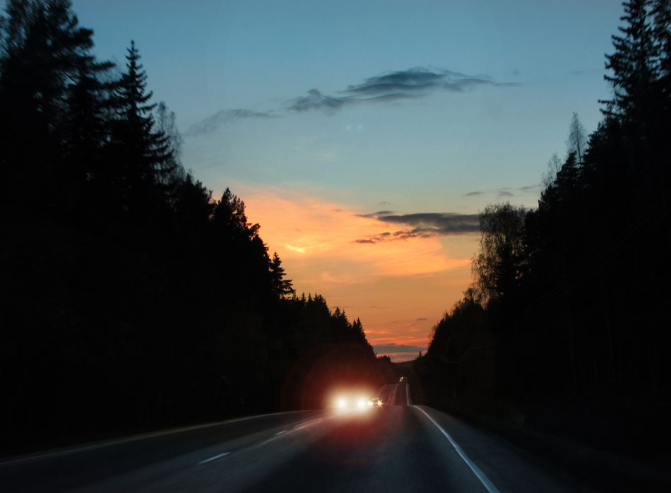 Glare of car’s headlights at sunset