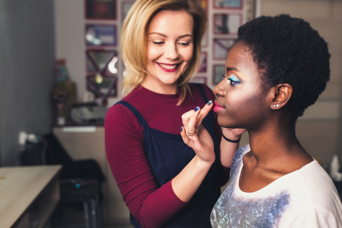 makeup artist applying makeup to young woman