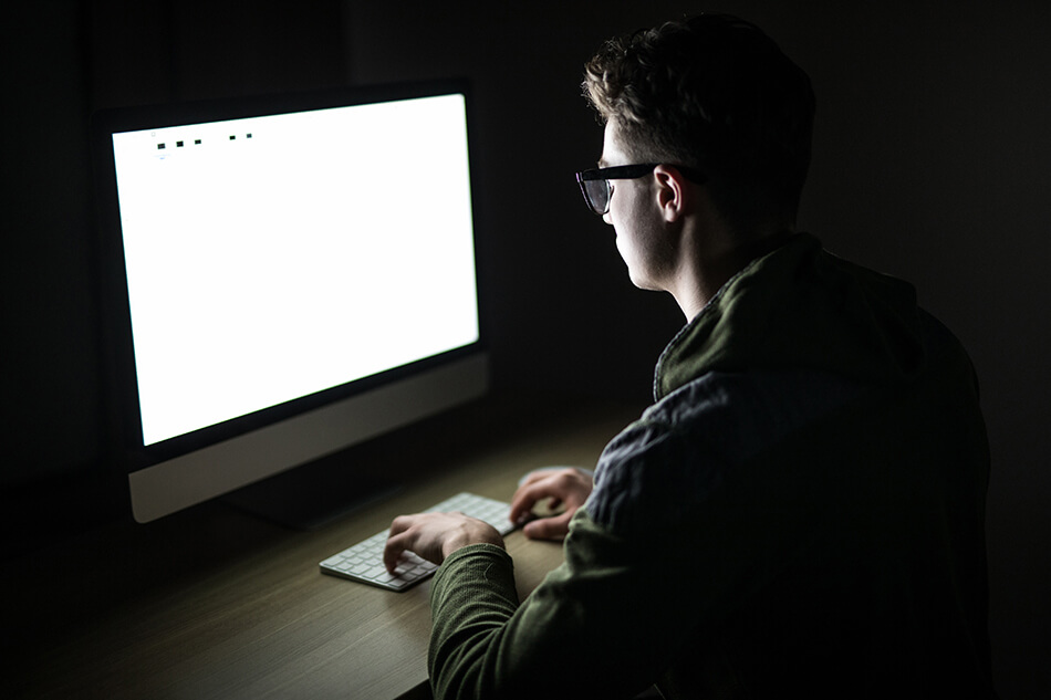 Man using computer in dark room