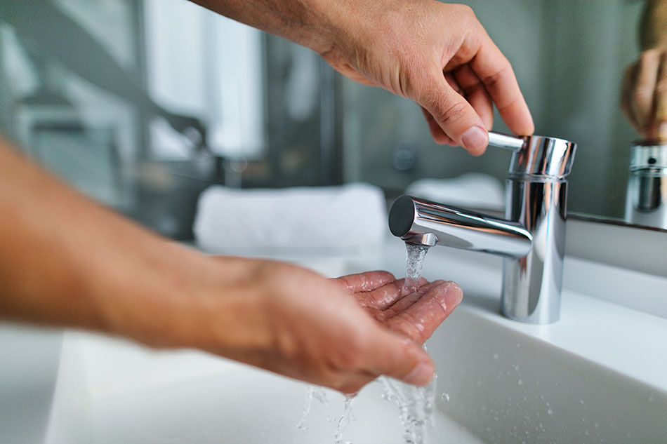 man washing hand under sink faucet