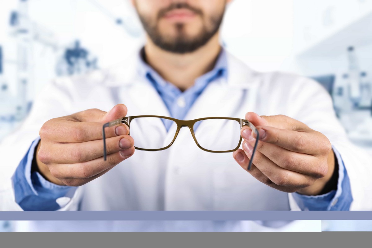 optometrist holding out a pair of glasses