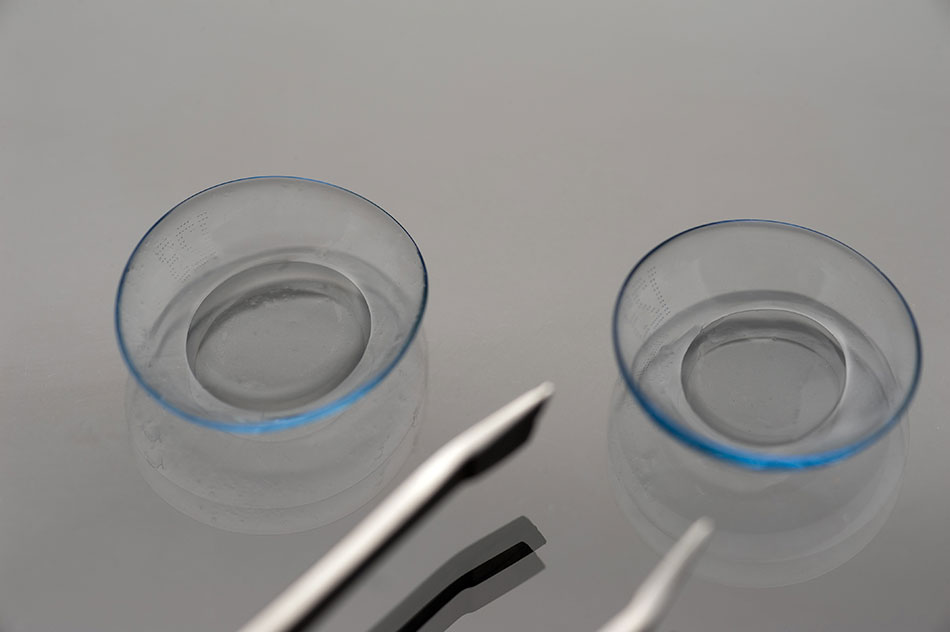 Pair of contact lenses with tinted edges and tweezers