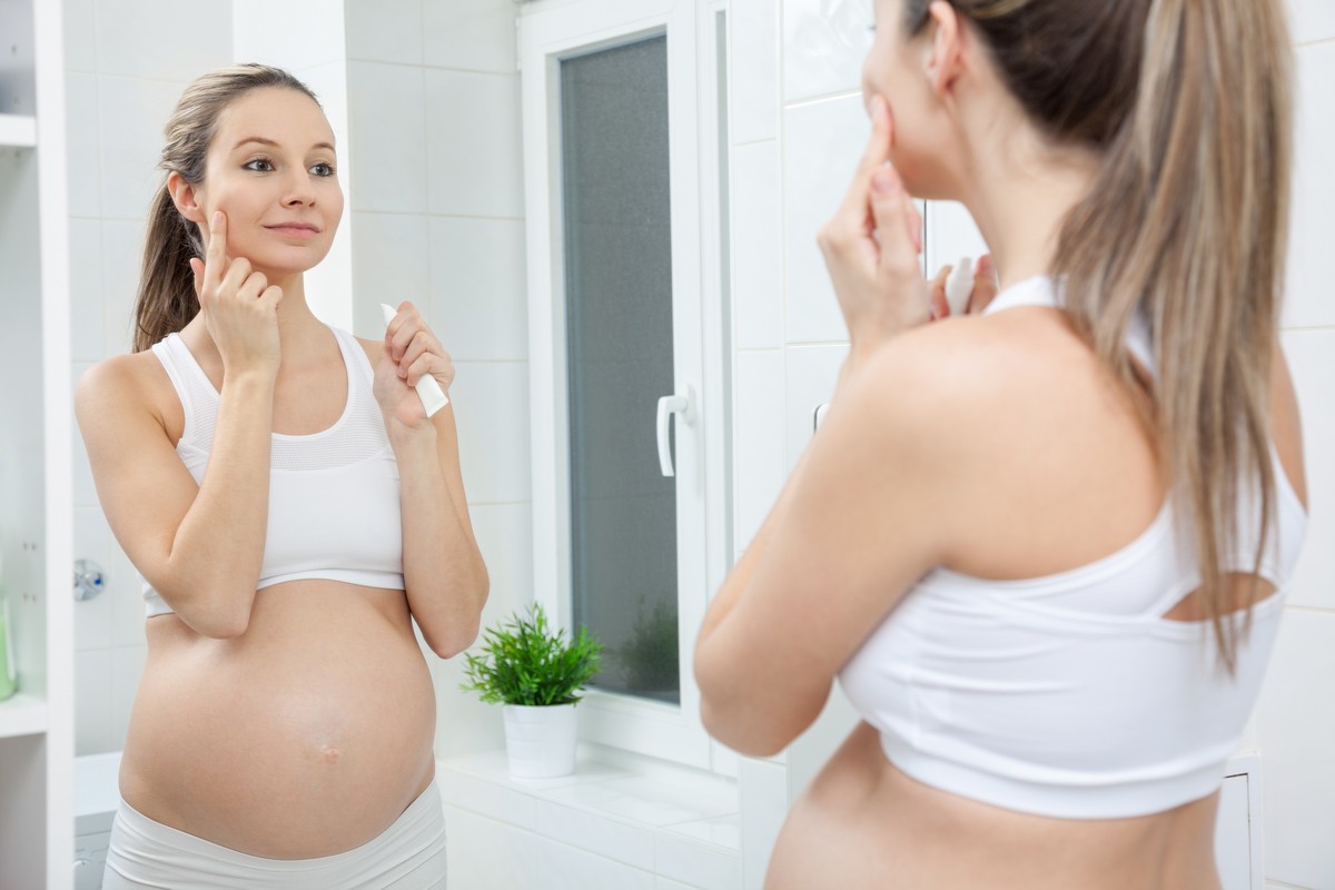 woman in mirror checking dry eyes during pregnancy