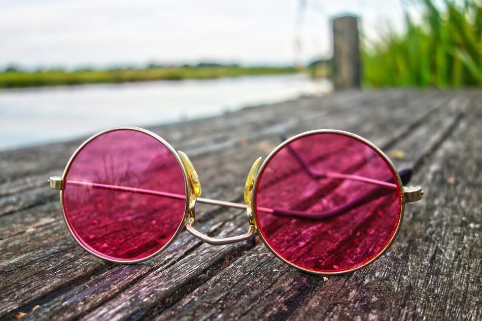 Rose color glasses on a wooden dock