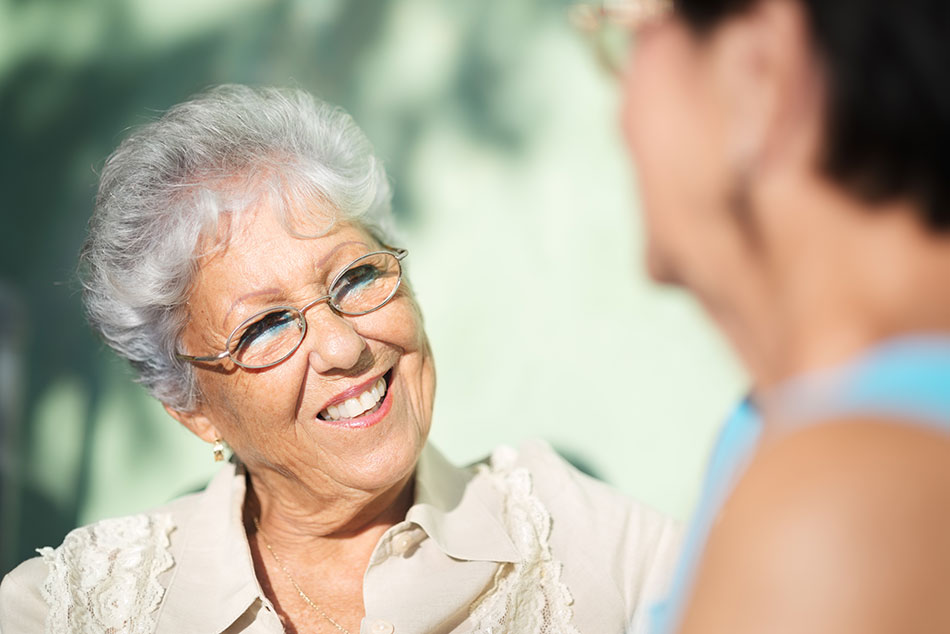 senior woman wearing glasses talking with a friend