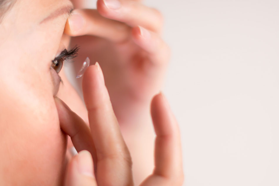 side view of woman inserting contact lens