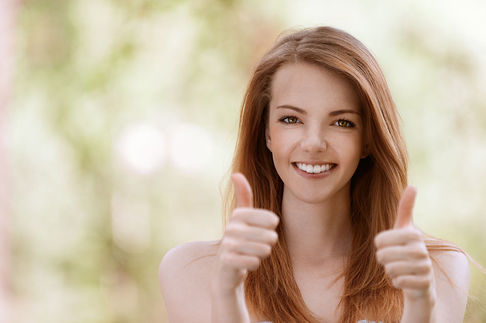 Young woman smiling and giving thumbs up