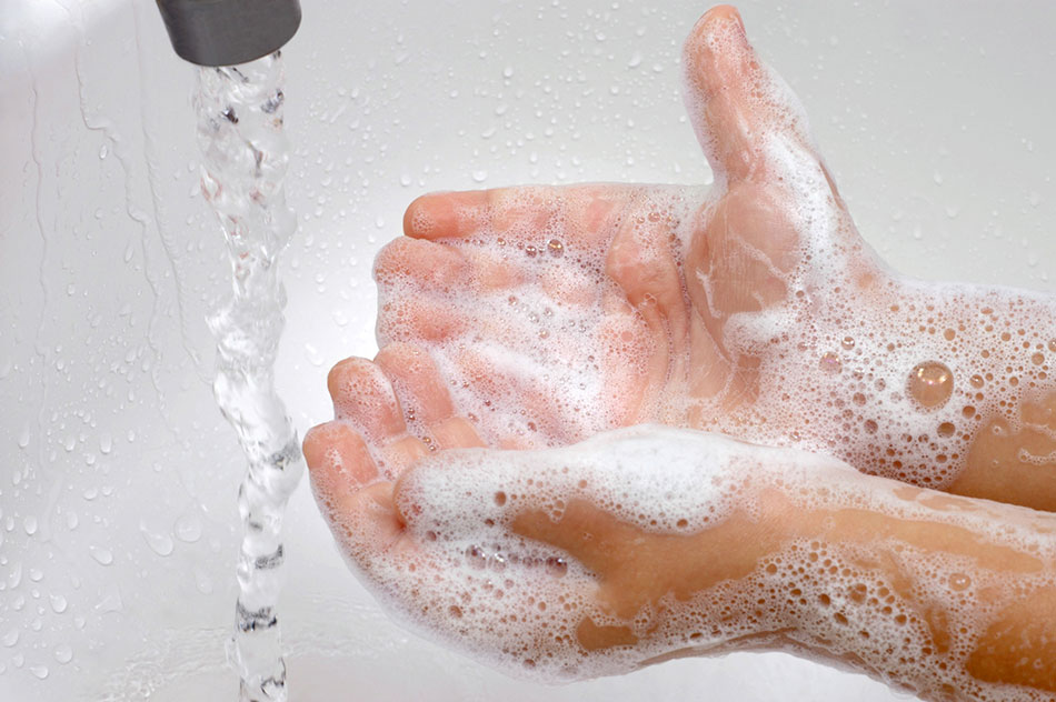 Washing hands with soap under running tap