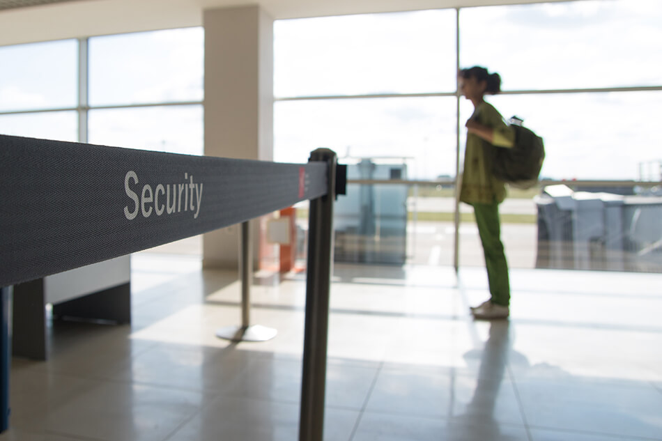 woman carrying backpack waiting at airport security