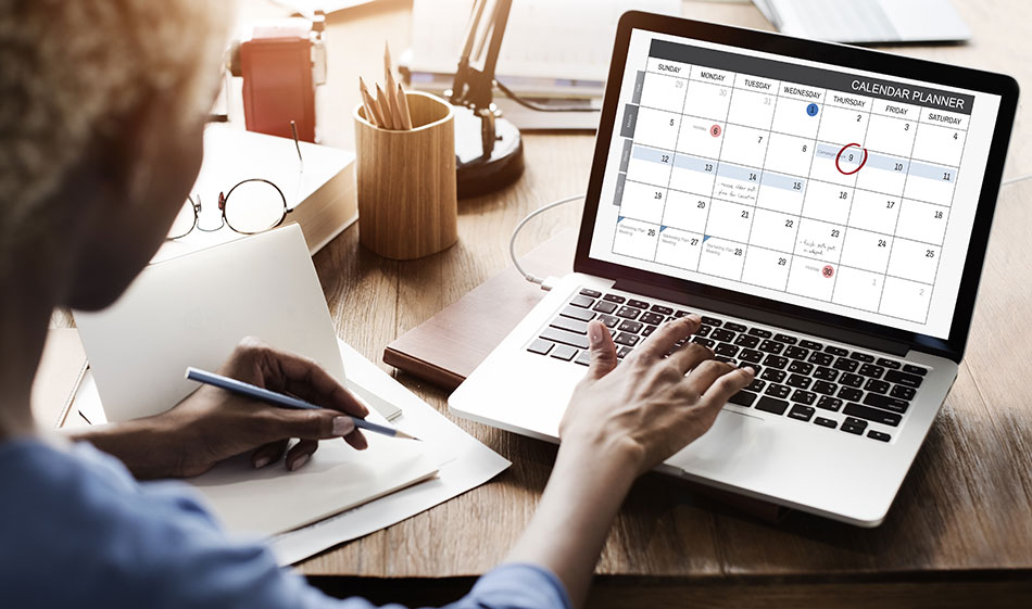 woman looking at calendar reminder on laptop