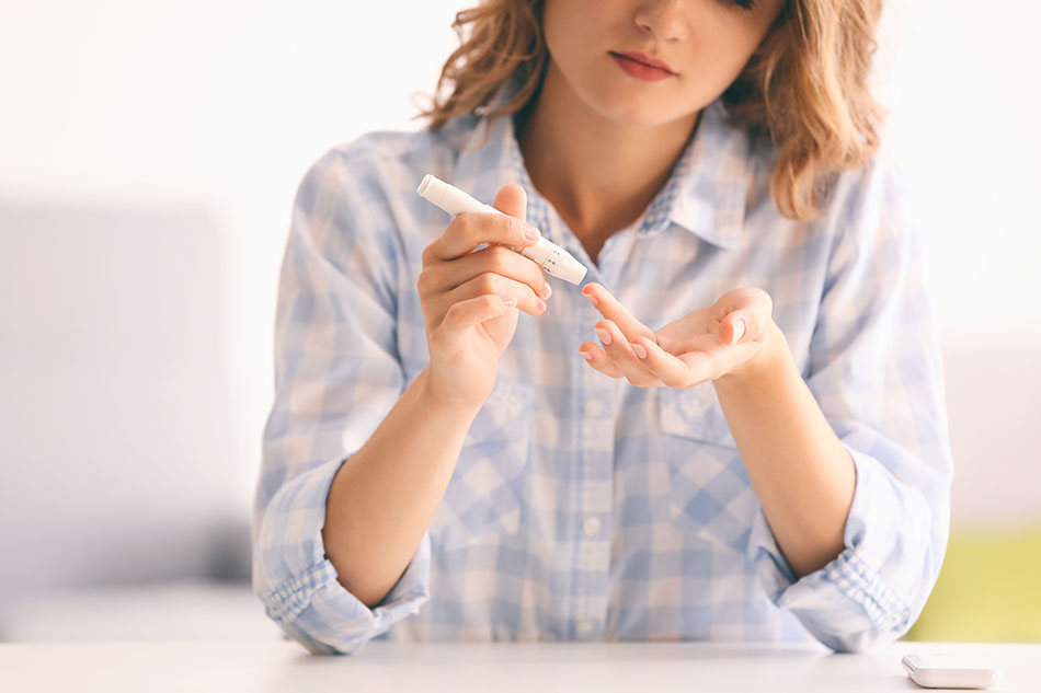 Woman checking glucose levels by poking her finger