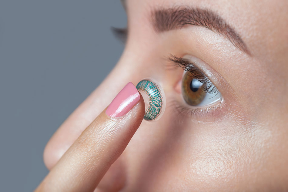 woman inserting colored contact lens