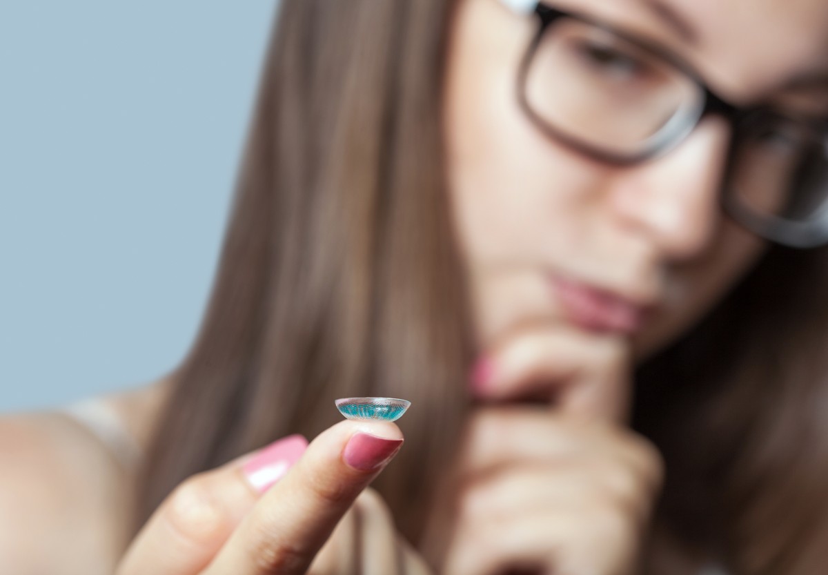 woman with contact lens on finger