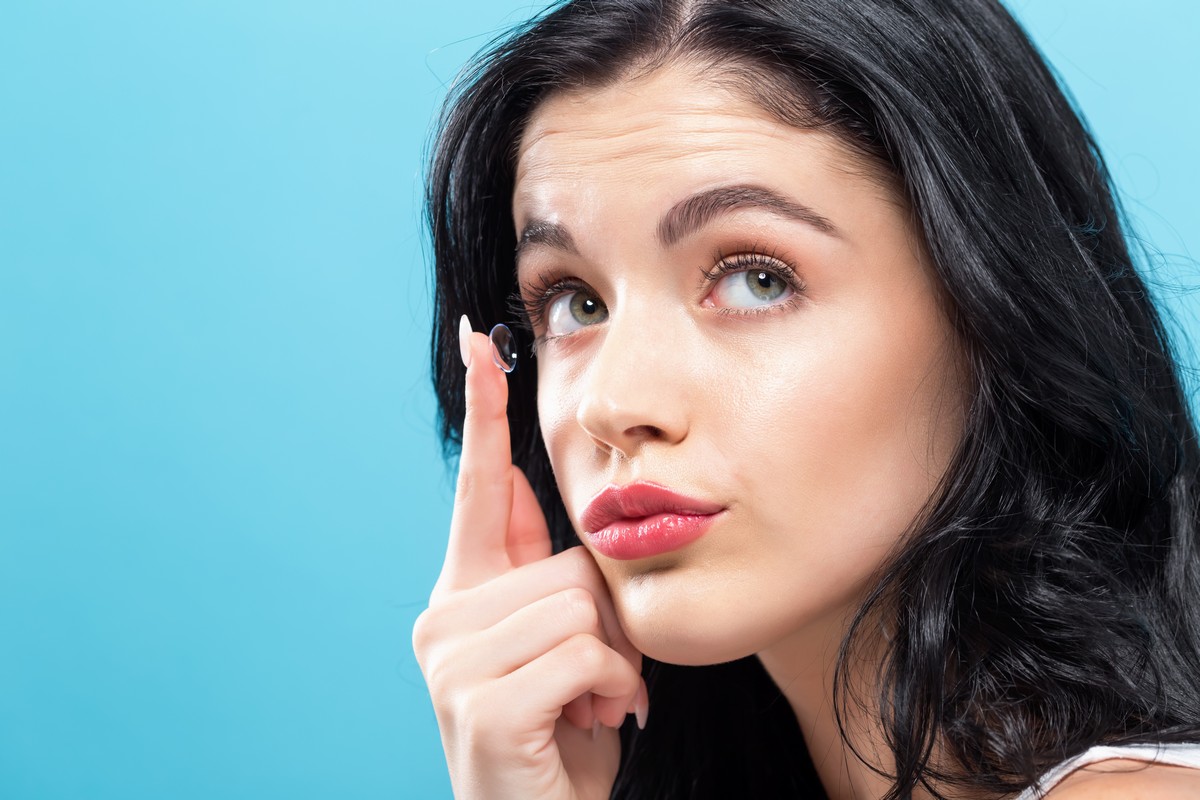 Woman with contact lens on finger