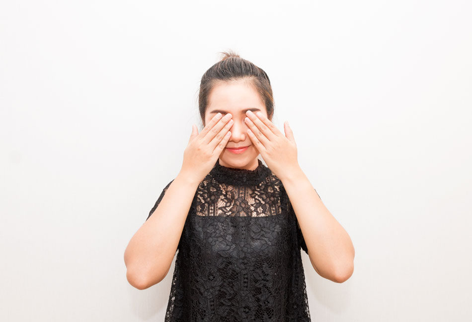 Woman covering eyes with fingers