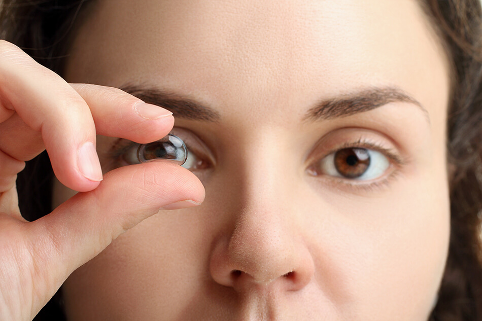 woman holding lens giving impression she has a stuck contact lens on her eye