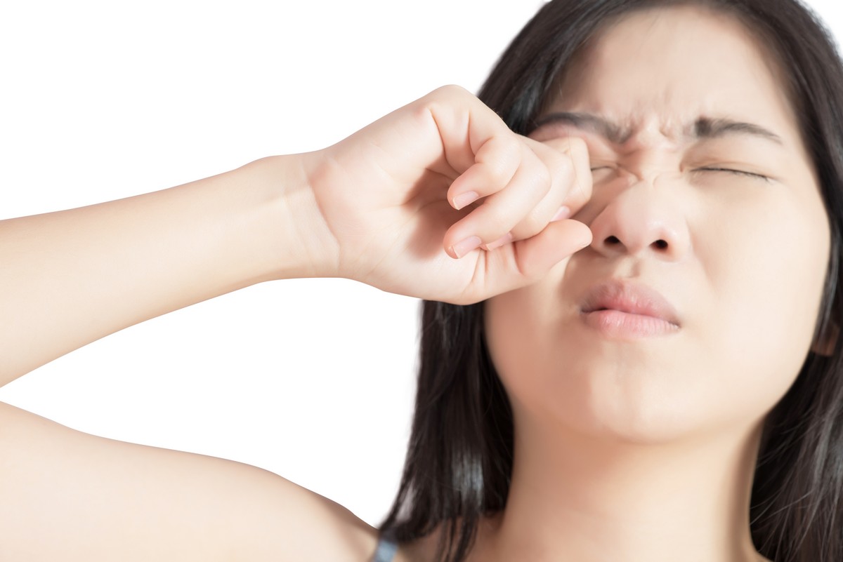 woman rubbing right eye