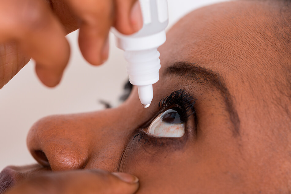 woman rinsing her eye with saline solution