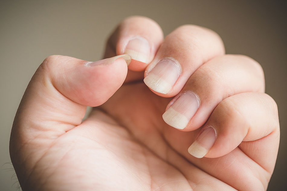 Woman’s hand with very long fingernails