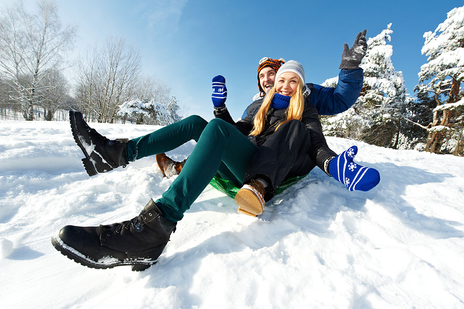 young couple sledding in snow