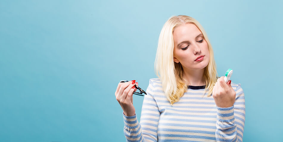 young woman considering glasses versus contacts